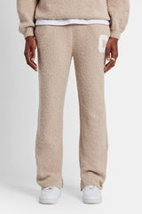 male model wearing the textured spit hem knitted jogger in beige