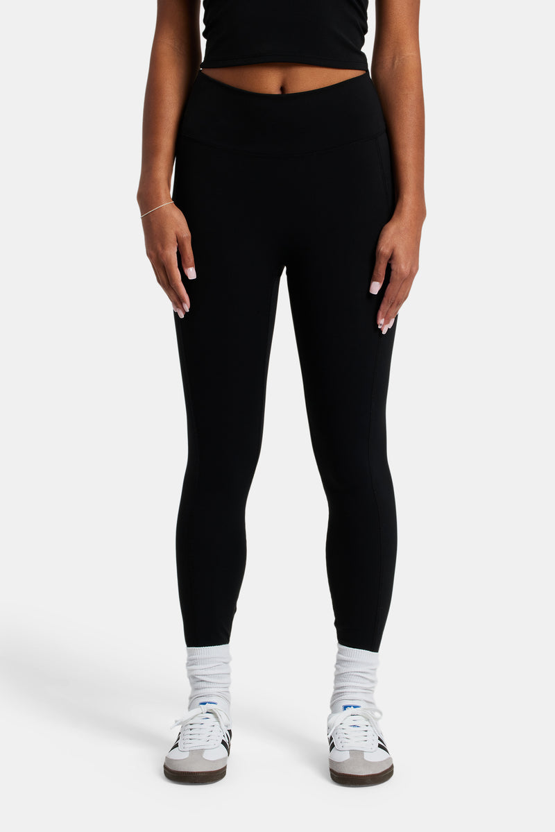 Female model wearing the deep waistband leggings in black